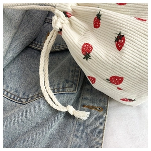 Detailansicht der Beuteltasche aus Cordsamt mit Erdbeermuster auf einer Jeansjacke
