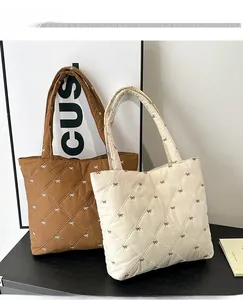 Detail of quilted tote bags featuring elegant bow embroidery and soft padded texture