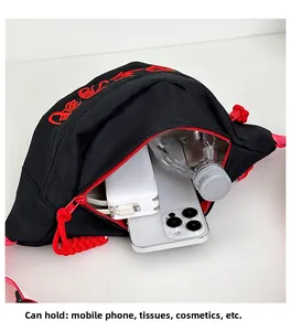 Detail van canvas heuptas met ruimte voor telefoon, powerbank en waterflesje