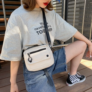 Minimalist canvas crossbody bag in beige with adjustable strap and multi-pocket design