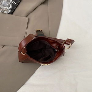 Vista dall'alto della borsa marrone in pelle con tasca zip e fibbia dorata