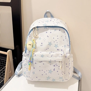 Detailed close-up of a white canvas backpack with star prints and a yellow bird plush charm