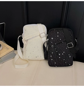 Detail view of nylon crossbody phone bags in black and beige with silver star patterns