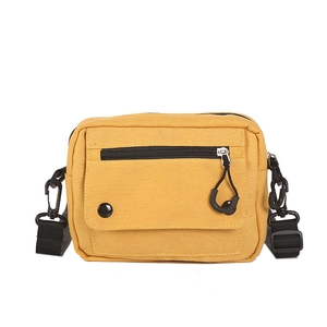 Minimalist bright yellow canvas crossbody bag with adjustable black strap and flap pocket