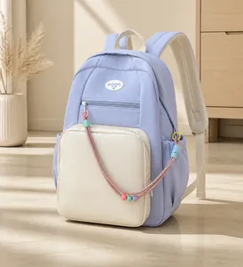 Dettaglio zaino in nylon azzurro con corda di perline colorate e tasca frontale con cerniera