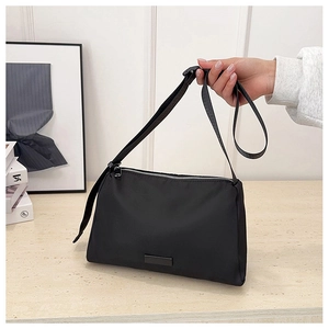 Detailed close-up of a black nylon crossbody bag with metal zipper and adjustable strap