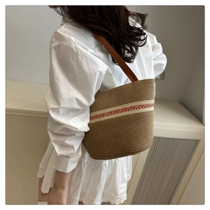 Détail du sac cabas en paille tissée avec bandoulière ethnique et anse en cuir