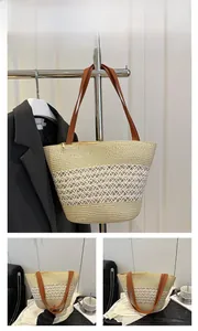 Détail d'un sac cabas en paille tissé à la main avec rayures bicolores et anses en cuir