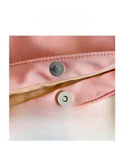 Detail shot of the secure magnetic silver buckle and precision stitching on the pink nylon tote