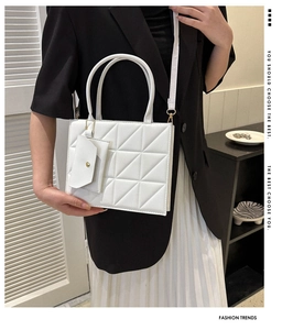 Detailed view of white quilted PU leather handbag with detachable mini pouch on model