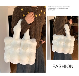 Detail view of large white plush tote bag with quilted bubble texture and wide shoulder strap