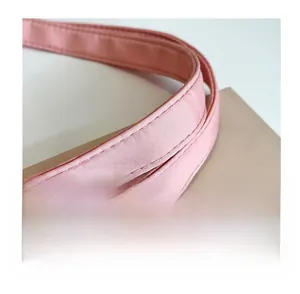 Close-up of reinforced stitching on the pink nylon tote bag handle for added durability