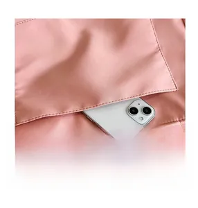 Detailed close-up of a pink nylon tote bag showing the front pocket for smartphone storage