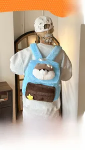 Detail of plush cartoon backpack featuring a blue otter design and a yellow star accessory