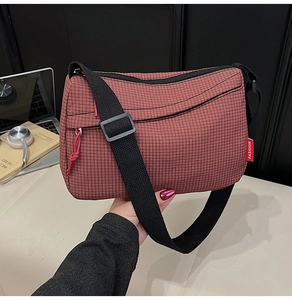 Detailed macro view of the checkered nylon crossbody bag with fashion red label