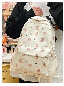 Close-up of cute bear print and large front pocket on cream canvas student backpack