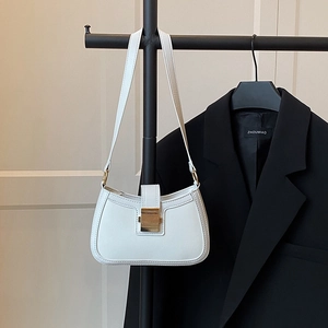 Dettaglio di una borsa baguette in ecopelle bianca con fibbia rettangolare dorata