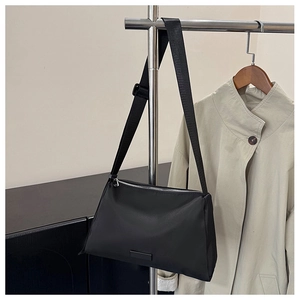 Close-up of black crossbody bag featuring adjustable strap and silver metal zipper detail