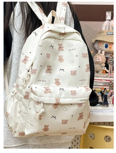 Detail of white backpack featuring cute brown bear prints and a functional side pocket