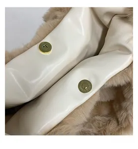 Detail view of golden magnetic closure on the plush faux fur tote bag interior