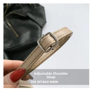 Detail of adjustable beige PU leather shoulder strap with silver metal buckle and stitching