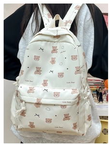 Detail of cute cream bear pattern backpack with bows and side drawstring pocket