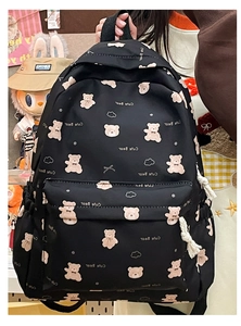 Detail view of the black backpack featuring pink bear and cloud prints and side pocket