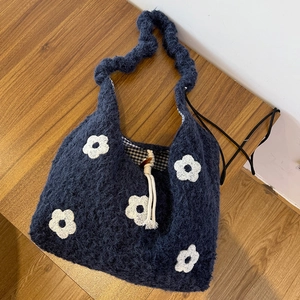 Detail view of navy faux fur tote bag with white flower embroidery and gingham lining
