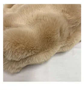 Macro close-up showing the soft plush faux fur texture and bottom stitching of the camel tote
