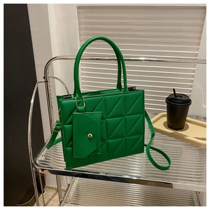 Detail view of emerald green tote bag with geometric quilting and mini coin purse charm