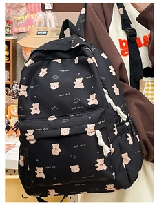 Detail of cute black bear backpack featuring pink patterns and white woven rope zipper pulls