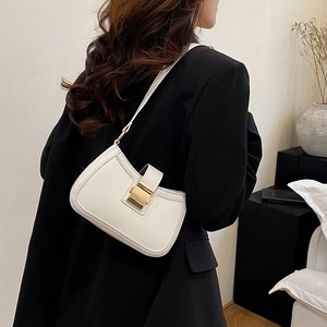 Dettaglio di un'elegante borsa a spalla in pelle bianca con fibbia dorata su un modello