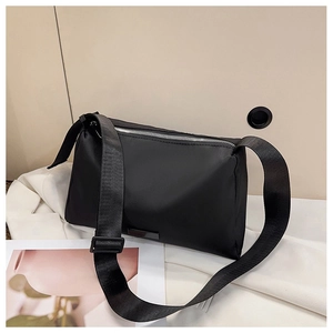 Detail of black waterproof nylon crossbody bag with wide strap and silver zipper closure