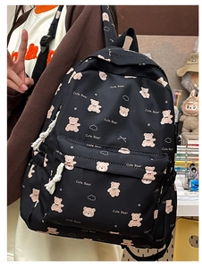 Detail of cute bear pattern on black canvas backpack with zippered front pocket
