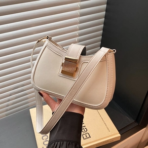 Dettaglio della borsa in pelle bianco crema con grande chiusura in metallo dorato a mano
