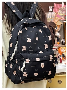 Detail view of black bear print backpack featuring pink plush patterns and cord zippers