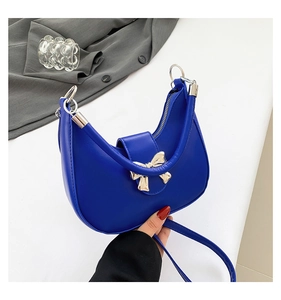 Vue détaillée du sac croissant bleu cobalt avec boucle dorée en forme de nœud