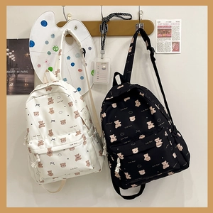 Detailed view of canvas backpacks in black and white with cute brown bear prints