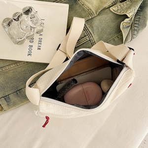 Cream white nylon crossbody bag with grid texture and spacious interior storage
