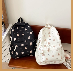 Detail of cute bear printed backpacks in black and white on a wooden bench