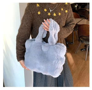Detailed texture of light blue faux fur tote bag with soft fluffy shoulder straps