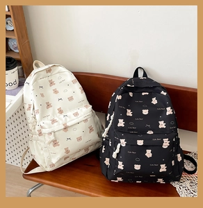 Detail view of cream and black backpacks featuring cute bear prints and spacious compartments