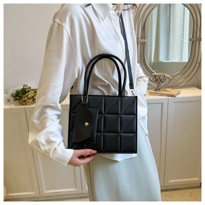Classic black quilted crossbody bag with small coin purse shown in a stylish home setting