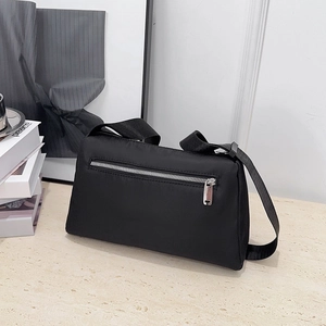 Minimalist black nylon crossbody bag with functional back zipper pocket and wide strap