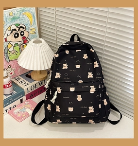 Detail of black canvas backpack featuring cute bear prints and front zipper pocket