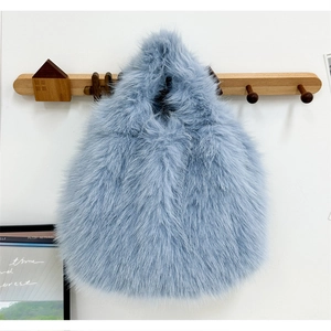 Vue détaillée d'un sac à main bleu clair en fausse fourrure sur un crochet en bois mural