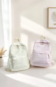 Gros plan d'un sac à dos en toile blanche avec motif de chat et nœud décoratif