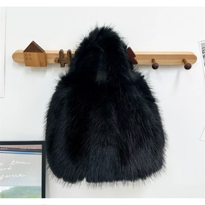 Détail du sac à main en fausse fourrure noire suspendu à un crochet mural en bois décoratif