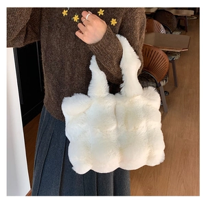 Detail of soft white faux fur tote bag showing the plush texture and wide shoulder strap