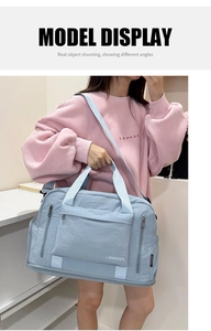 Light blue large capacity travel duffel bag with shoulder strap shown on a model